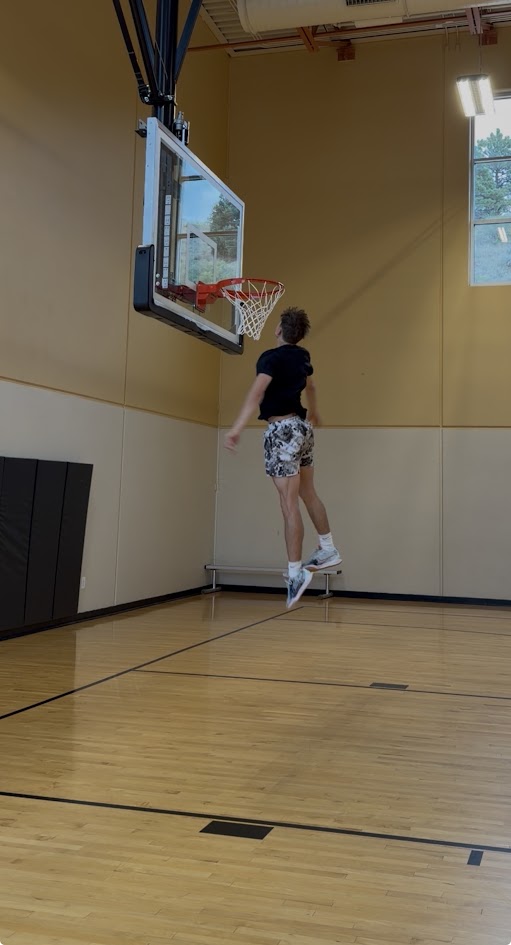 Jake jumping toward the rim with his hand up at the net